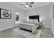 Bright bedroom with a queen size bed, bedside lamps, and a large window overlooking a lush, green outdoor space at 1085 Harts Bluff Rd, Wadmalaw Island, SC 29487