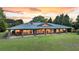 Stunning brick home with a green metal roof, porch columns, and large manicured front yard at 1085 Harts Bluff Rd, Wadmalaw Island, SC 29487