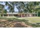 Expansive one-story brick home with covered porches, a metal roof, and an ample lawn and mature trees at 1085 Harts Bluff Rd, Wadmalaw Island, SC 29487