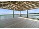 Interior view of a pier gazebo showcasing its wooden deck, railing and an open view of the water and sky at 1085 Harts Bluff Rd, Wadmalaw Island, SC 29487