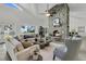 Bright living room featuring a stone fireplace, lots of natural light, and views of the waterfront at 1085 Harts Bluff Rd, Wadmalaw Island, SC 29487