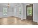 Dining room featuring wainscoting, large windows, an elegant chandelier, and a dark wood door at 1098 Reserve Ln, Awendaw, SC 29429