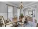Bright dining room with a wooden table, six chairs, a chandelier, and natural light streaming through the windows at 1098 Reserve Ln, Awendaw, SC 29429