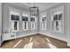 Charming dining room featuring hardwood floors, abundant windows, and a modern chandelier at 1098 Reserve Ln, Awendaw, SC 29429