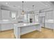 Bright, white kitchen features an island, stainless steel appliances, and stylish pendant lighting at 1098 Reserve Ln, Awendaw, SC 29429