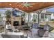 Outdoor fireplace and living area with a fan, TV and comfortable seating at 1098 Reserve Ln, Awendaw, SC 29429