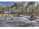 Beautiful backyard pool, spa, and outdoor dining area surrounded by lush greenery at 1098 Reserve Ln, Awendaw, SC 29429