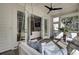 Covered porch featuring cushioned swing, ceiling fan, and view to living room at 1098 Reserve Ln, Awendaw, SC 29429