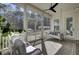 Relaxing screened porch with comfortable seating, ceiling fan, and view of the backyard at 1098 Reserve Ln, Awendaw, SC 29429