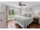 Light-filled bedroom featuring hardwood floors, a ceiling fan, and a large window offering a view of the backyard at 1129 Shady Grove Ln, Mount Pleasant, SC 29464
