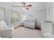 Cozy Bedroom with a gray crib, comfortable armchair, patterned rug, and a window with natural light at 1129 Shady Grove Ln, Mount Pleasant, SC 29464