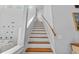 Bright staircase with wooden steps, white risers, and a handrail, with pictures on the wall at 1129 Shady Grove Ln, Mount Pleasant, SC 29464