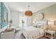 Bright bedroom with white bedding, unique light fixture, and patterned accent wall at 114 Rust Rail Way, Summerville, SC 29485