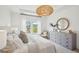Bright main bedroom featuring large windows with lake views and a stylish dresser at 114 Rust Rail Way, Summerville, SC 29485