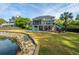 Expansive backyard with a swimming pool, mature trees, lush lawn and tranquil pond view at 1143 Sea Eagle Watch, Charleston, SC 29412