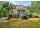Charming two-story home with dual porches, lush greenery, and a meticulously maintained front lawn at 1143 Sea Eagle Watch, Charleston, SC 29412