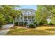 Elegant two-story home with double porches surrounded by mature trees and a well-manicured lawn at 1143 Sea Eagle Watch, Charleston, SC 29412