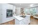 Elegant kitchen with white cabinets, quartz countertops, stainless steel appliances and wooden flooring at 1143 Sea Eagle Watch, Charleston, SC 29412