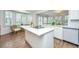 Sunlit kitchen featuring white cabinets, a marble countertop island, stainless steel appliances and hardwood floors at 1143 Sea Eagle Watch, Charleston, SC 29412