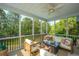 Inviting screened porch featuring comfortable seating, ceiling fan, and views of the lush backyard and pond at 1143 Sea Eagle Watch, Charleston, SC 29412