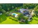 An aerial view of a lovely house, a pool and solar panels, all surrounded by lush greenery at 120 Greenhill Pastures, Summerville, SC 29483