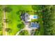 Aerial view of a home with dark roof, pool, and solar panels, surrounded by lush greenery at 120 Greenhill Pastures, Summerville, SC 29483