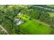 Aerial view of vast green property with a home, a pool, and large trees at 120 Greenhill Pastures, Summerville, SC 29483