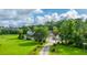 Expansive aerial view of a traditional home with green lawn, mature trees, and a circular driveway at 120 Greenhill Pastures, Summerville, SC 29483