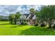 Traditional home with a brick facade, dormer windows and a large front yard surrounded by mature trees at 120 Greenhill Pastures, Summerville, SC 29483
