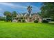 Charming two-story home with a covered porch, green lawn, mature trees, and manicured landscaping at 120 Greenhill Pastures, Summerville, SC 29483