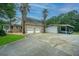 Spacious two car garage with a covered carport and large driveway with palm trees in front of a brick home at 120 Greenhill Pastures, Summerville, SC 29483
