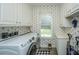 Well-organized laundry room with modern washer, dryer, ample storage, and delightful palm wallpaper at 120 Greenhill Pastures, Summerville, SC 29483
