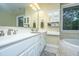 Luxurious primary bathroom with dual sinks, white cabinetry, and a window with a peaceful view at 120 Greenhill Pastures, Summerville, SC 29483