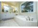 Serene primary bathroom featuring a soaking tub, dual vanities, and large bright window at 120 Greenhill Pastures, Summerville, SC 29483