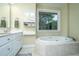 Bright primary bathroom with dual sinks, built-in storage, large window, and a soaking tub at 120 Greenhill Pastures, Summerville, SC 29483
