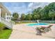 Backyard pool with a slide, lounge chairs and patio dining set for outdoor entertaining surrounded by green trees at 120 Greenhill Pastures, Summerville, SC 29483