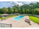 Backyard pool with lounge chairs and an umbrella-covered table, with privacy provided by the tall trees at 120 Greenhill Pastures, Summerville, SC 29483