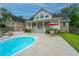 Backyard pool with an umbrella-covered table and chairs, with a covered patio in the background at 120 Greenhill Pastures, Summerville, SC 29483