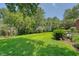 Backyard of the home featuring a grassy lawn, pond, mature trees and lush landscaping at 1208 Wynnwood Ct, Mount Pleasant, SC 29466