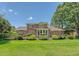 Wide shot of the exterior of the brick home with manicured lawn and professional landscaping at 1208 Wynnwood Ct, Mount Pleasant, SC 29466