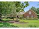 All brick home with mature landscaping and an American flag on a manicured front lawn at 1208 Wynnwood Ct, Mount Pleasant, SC 29466