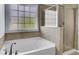 Bright bathroom featuring a soaking tub with tile surround and a clear glass shower at 123 Blackwater Way, Moncks Corner, SC 29461