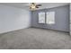 Spacious carpeted bedroom featuring a ceiling fan and bright natural light from the double windows at 123 Blackwater Way, Moncks Corner, SC 29461