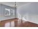 Spacious dining room with hardwood floors, wainscoting, a chandelier, and large windows for natural light at 123 Blackwater Way, Moncks Corner, SC 29461