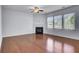 Bright living room with hardwood floors, a ceiling fan, fireplace, and large windows offering natural light at 123 Blackwater Way, Moncks Corner, SC 29461