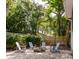 Secluded backyard featuring gravel, fire pit, Adirondack chairs, string lights, and a privacy fence at 1274 Hampshire Rd, Charleston, SC 29412