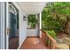 Charming front porch featuring a wooden deck, white railings, and a glass front door at 1274 Hampshire Rd, Charleston, SC 29412