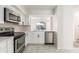 Well-lit kitchen showcasing white cabinets, stainless steel appliances, and a view to the dining area at 1274 Hampshire Rd, Charleston, SC 29412