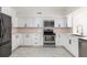 Bright and modern kitchen featuring white cabinets, stainless steel appliances, and tile flooring at 1274 Hampshire Rd, Charleston, SC 29412