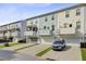 View of multiple three-story townhomes, each featuring a garage and an elevated outdoor porch at 136 Rowans Creek Dr, Charleston, SC 29492